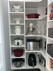 A kitchen pantry cabinet well organized to get to all the tools. There is a cute ceramic owl cookie jar in the 3rd shelf down on the left side.