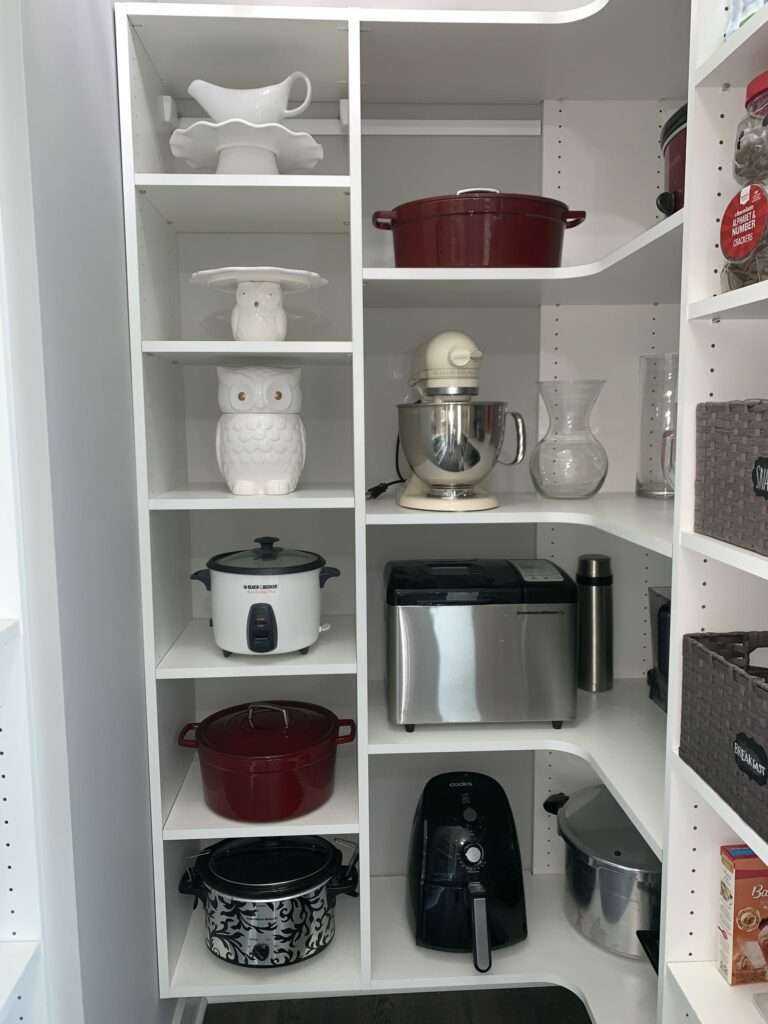 A kitchen pantry cabinet well organized to get to all the tools. There is a cute ceramic owl cookie jar in the 3rd shelf down on the left side.