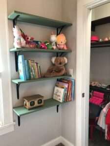 Book shelves and a peek into a closet with pink hangers.