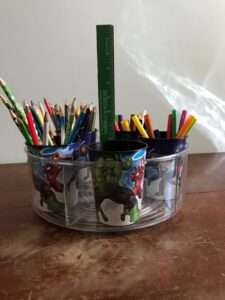 A container with cups for pencils and markers.