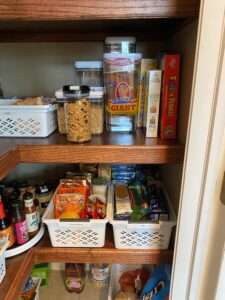Plastic bins and vacuum seal plastic storage containers on the shelf.