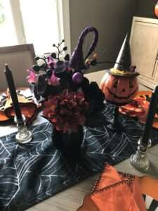 Halloween tablescape with pumpkin in black pointy hat.