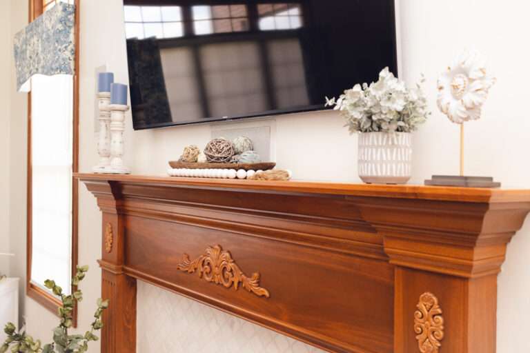 Close up of the mantel place, with small natural decorations in white adorning it.