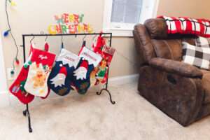 Festive stockings hanging on a wrought iron stocking hanger with hooks.